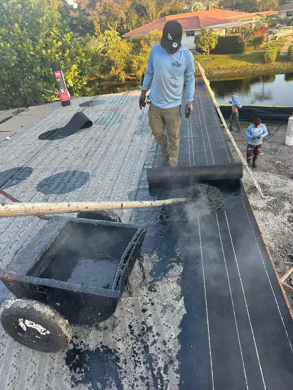 Workers laying asphalt on the roof